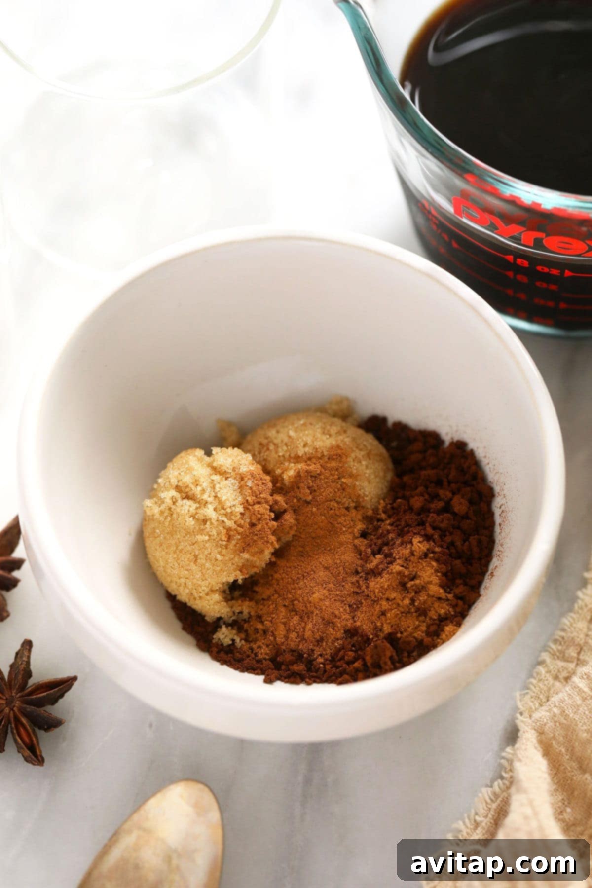 A bowl filled with a mixture of brown sugar, instant coffee granules, and pumpkin pie spice, ready to be whipped into dalgona foam. 