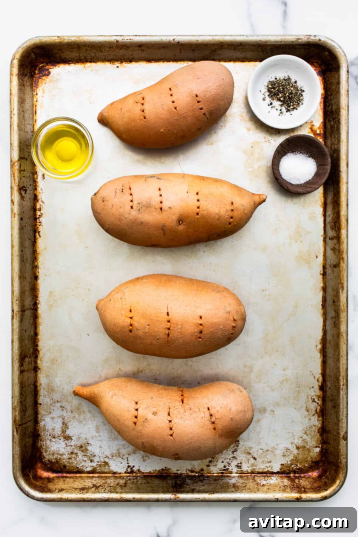 Sweet potatoes on a baking sheet before baking.