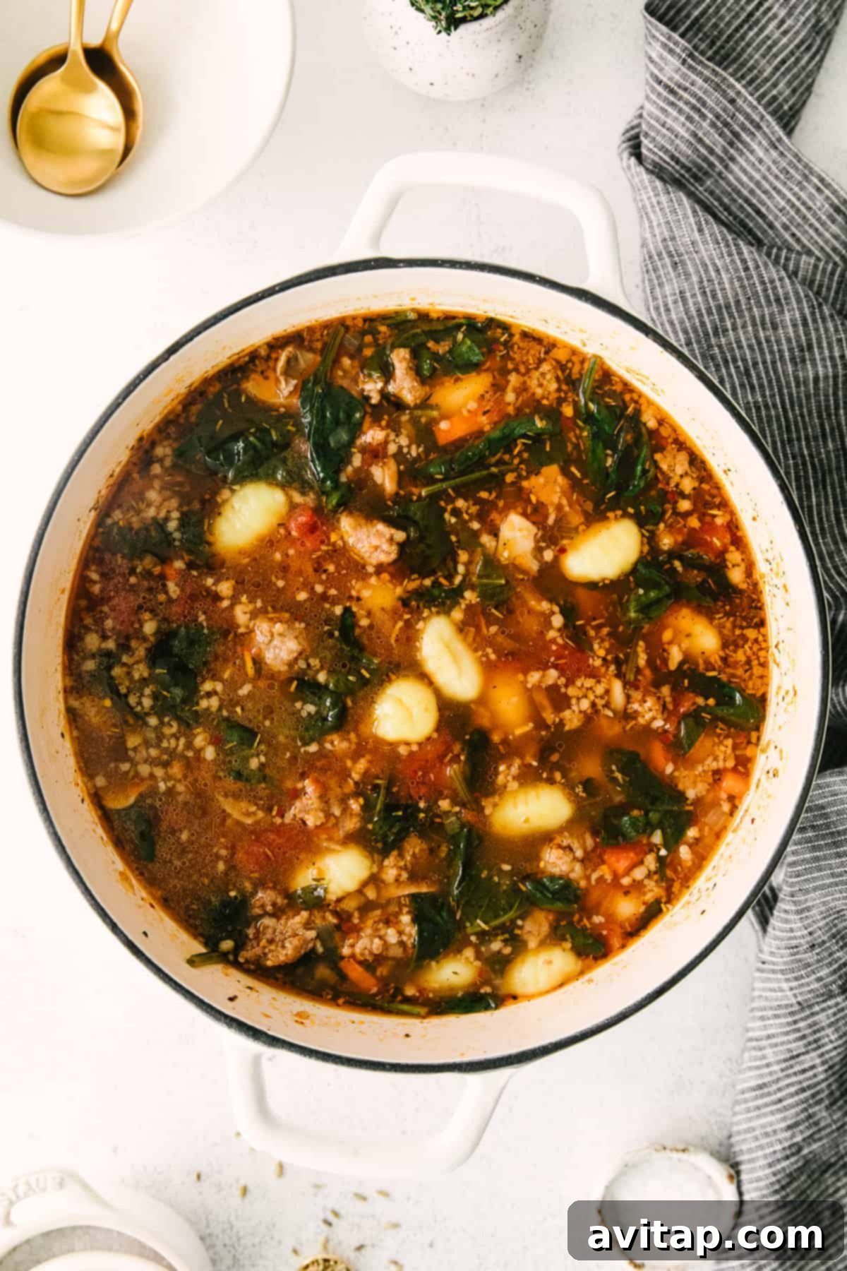 Close-up of a stock pot filled with delicious sausage gnocchi soup, showing the tender gnocchi floating at the top, indicating they are perfectly cooked and ready to serve.
