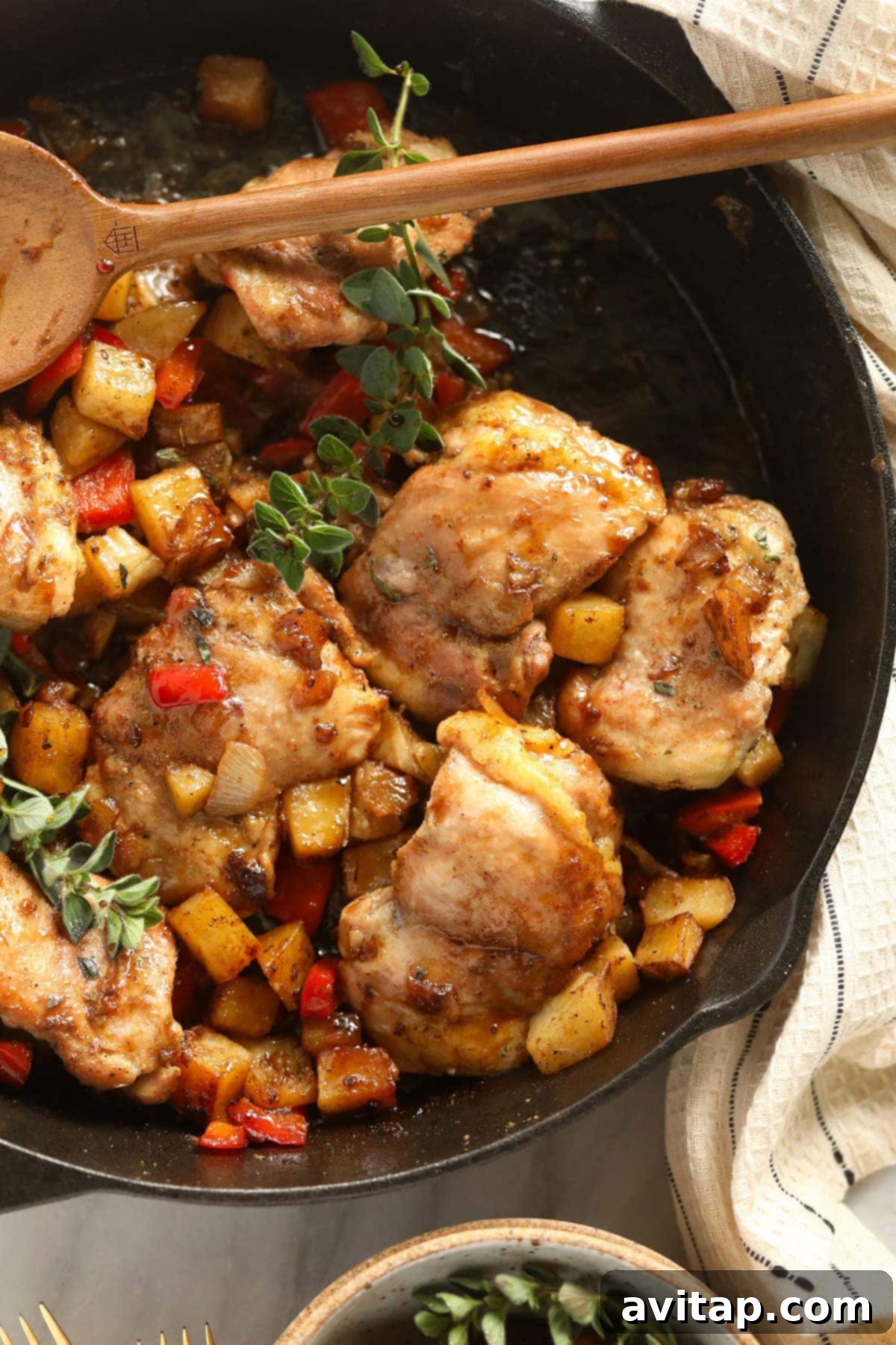 A stunning close-up of skillet chicken and potatoes, perfectly cooked and garnished, in a cast iron pan, ready for serving