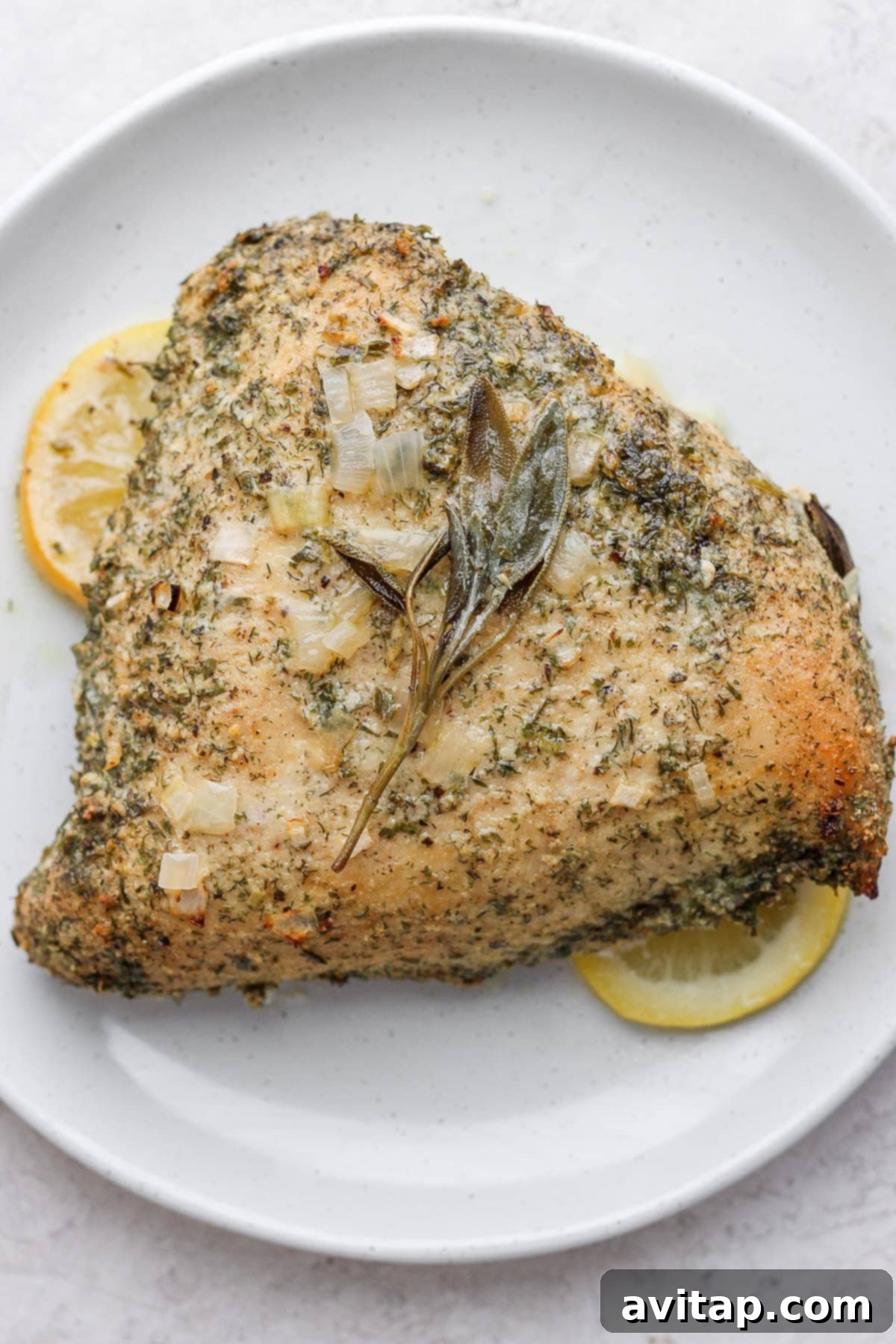A perfectly roasted turkey breast garnished with herbs on a elegant serving platter.