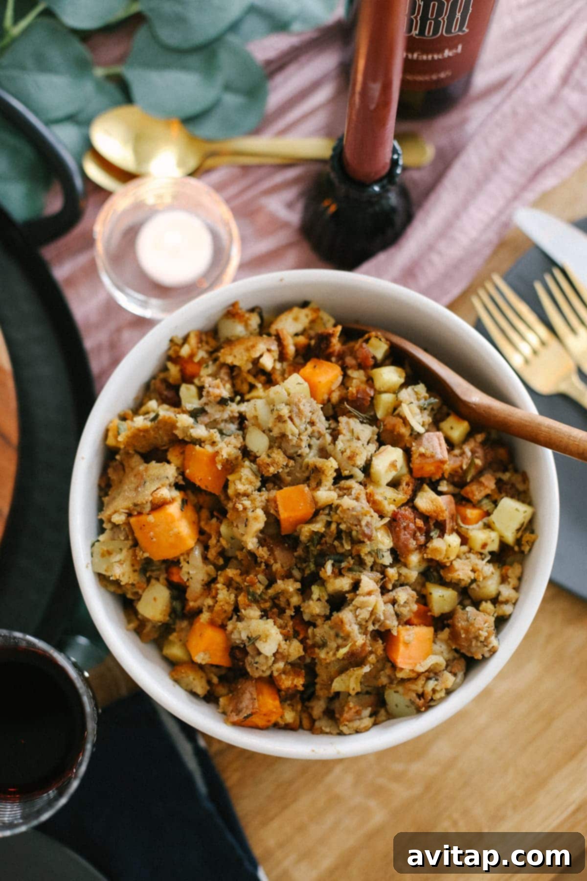 A serving of flavorful sausage stuffing in a rustic ceramic bowl, garnished with fresh herbs, ready to be enjoyed.