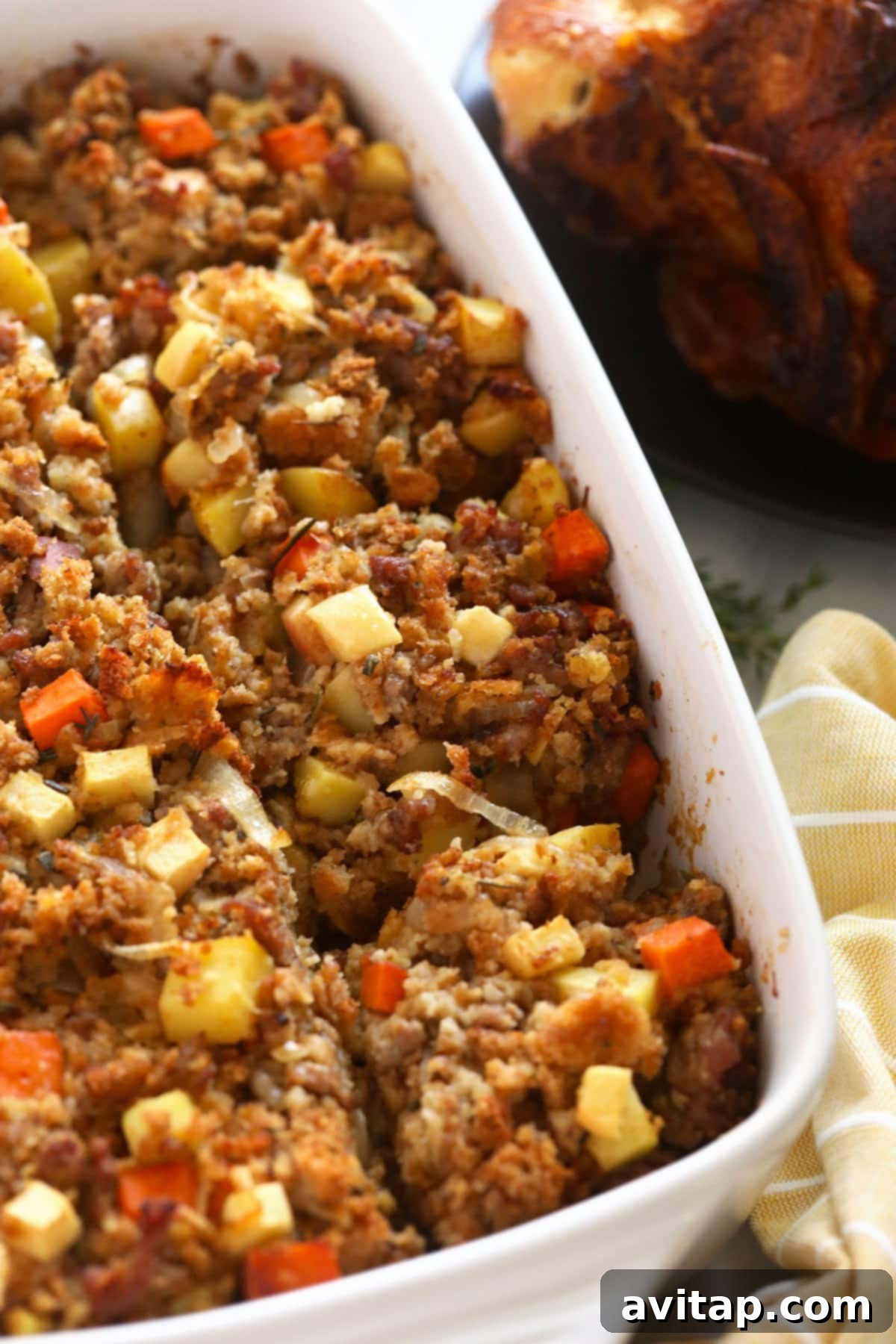 The golden-brown, baked sausage stuffing glistening with butter in a large casserole dish, fresh out of the oven.