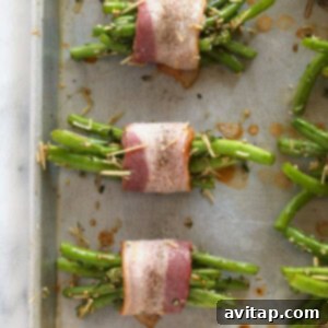 Assembling bacon wrapped green beans on a baking sheet.