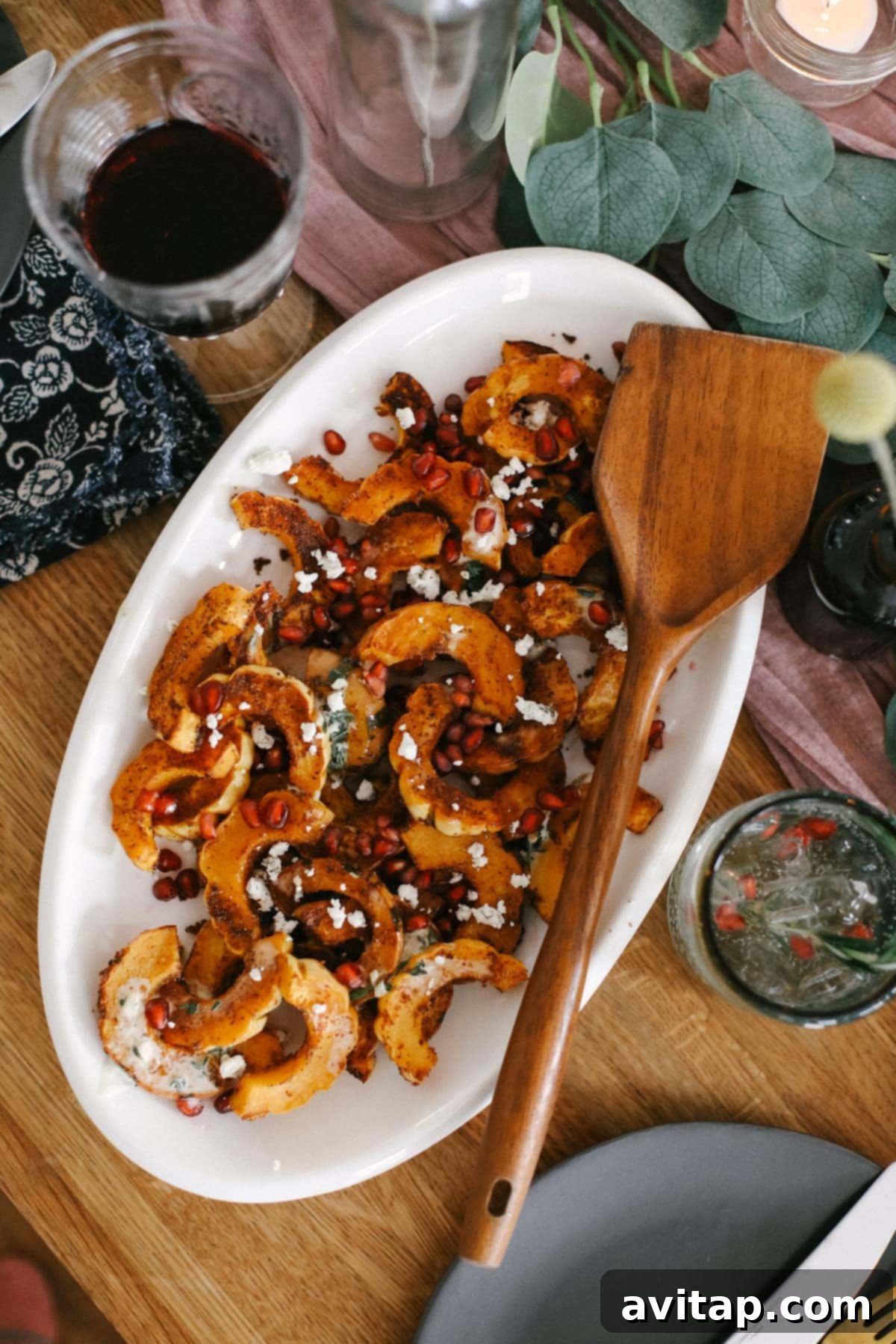Close-up view of roasted delicata squash with creamy garlic sauce and fresh thyme, beautifully plated and ready to be enjoyed.