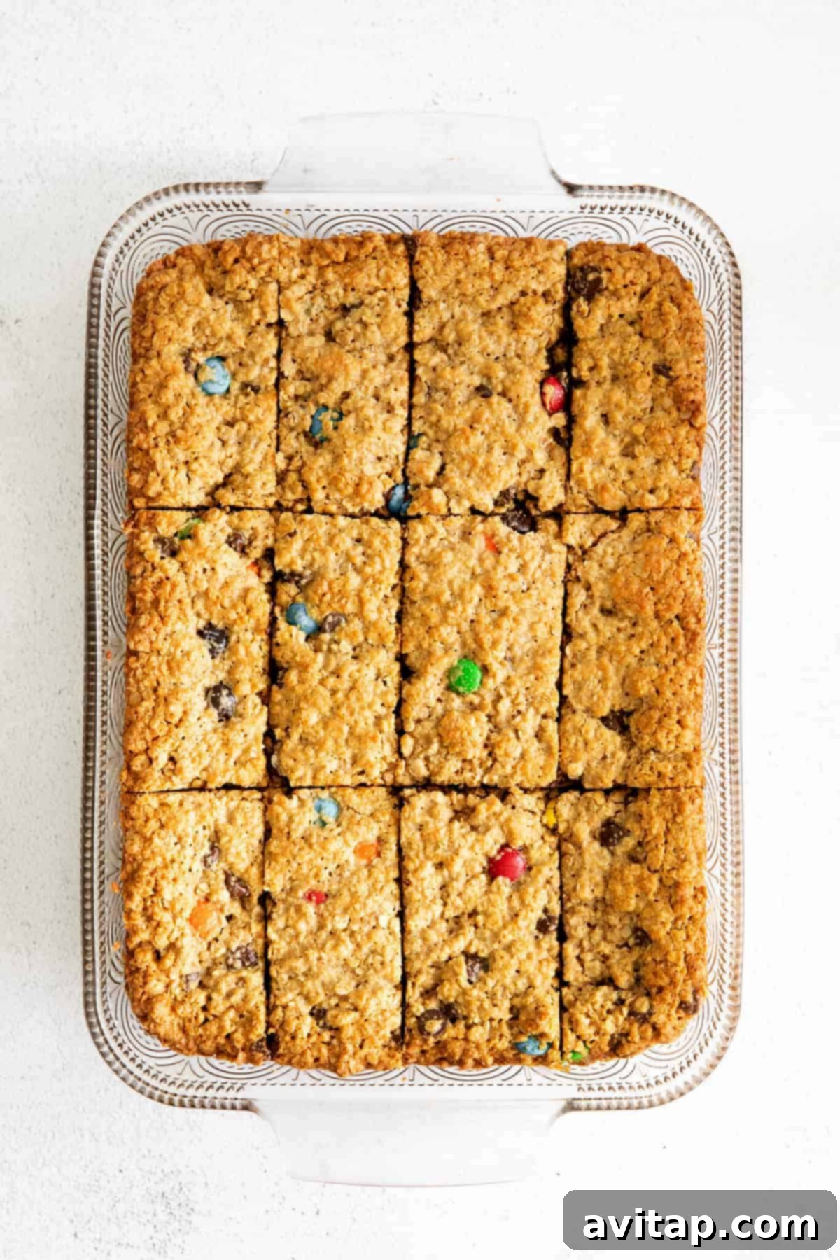 Delicious flourless monster cookie bars baked golden brown in a rectangular pan, ready for slicing.