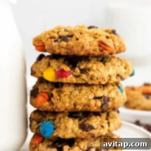 Stack of chewy flourless monster cookies, made with oats, peanut butter, chocolate chips, and M&M's.