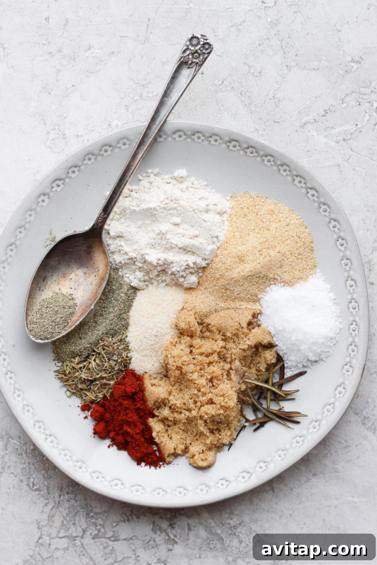 Savory Beef Stew Blend 5 A variety of beef stew seasoning spices arranged artfully on a white plate, showcasing their textures and colors.