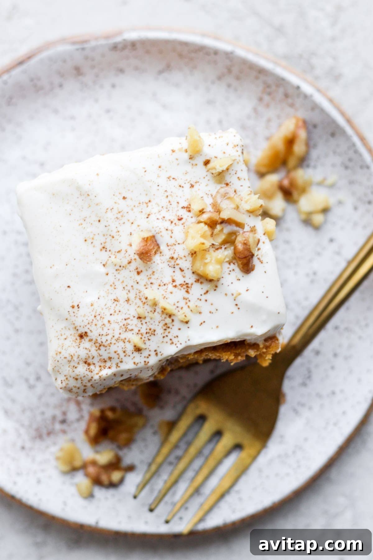 Delicious pumpkin cake with healthy cream cheese frosting A slice of pumpkin cake topped with generous healthy Greek yogurt cream cheese frosting, ready to be enjoyed.