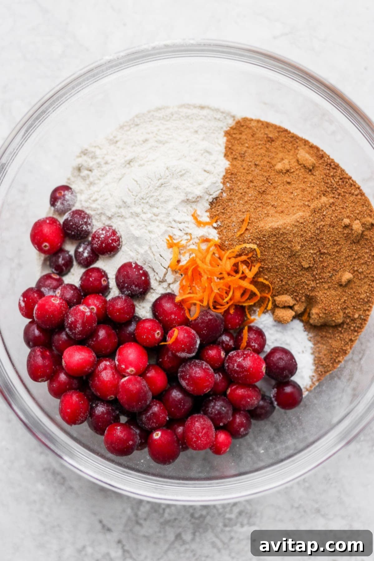 Dry ingredients for cranberry orange bread in a bowl, ready to be mixed.