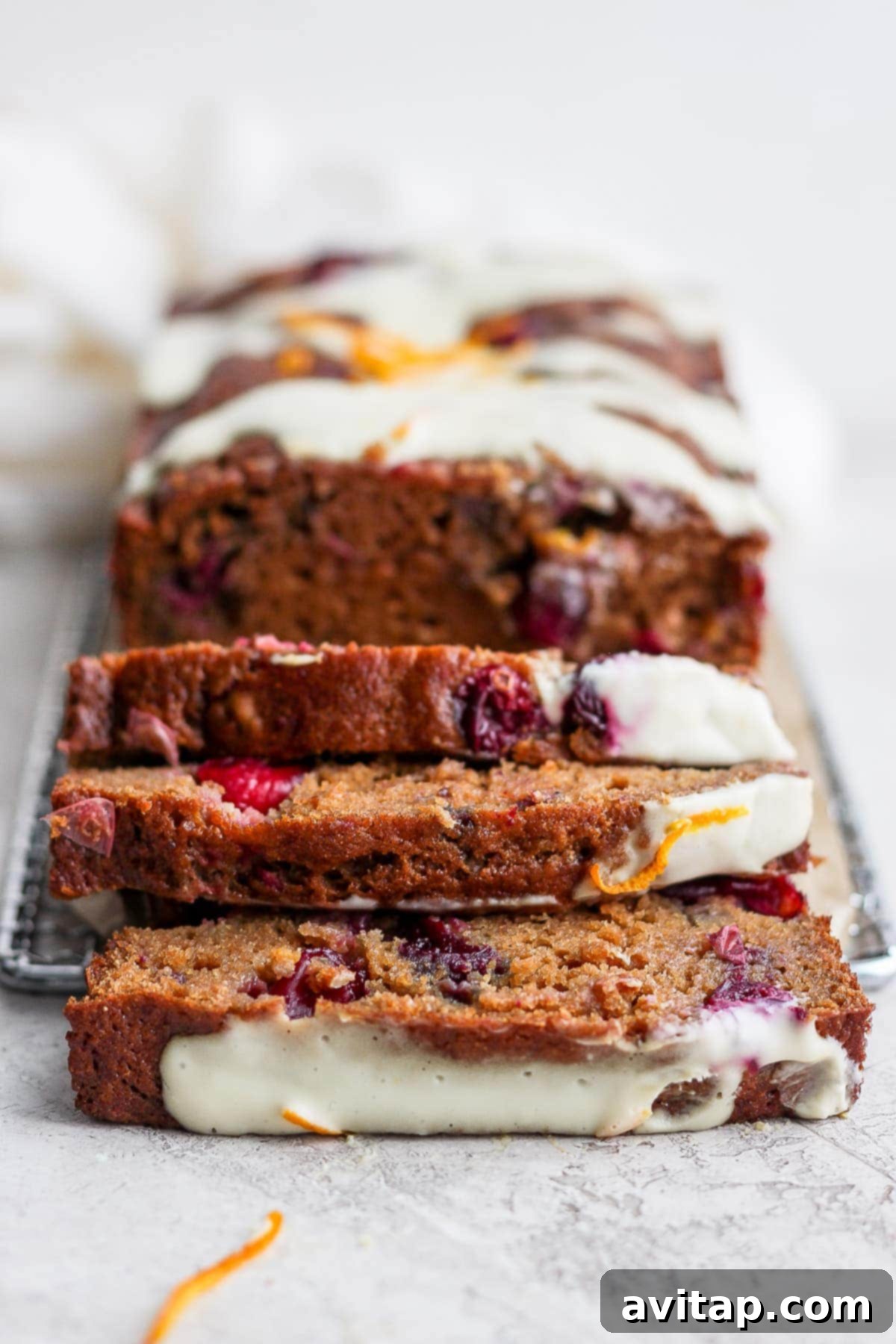 Beautifully sliced cranberry orange bread, showcasing its moist texture and cranberry studded interior.