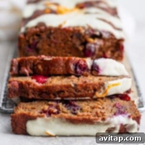 A loaf of delectable cranberry orange bread topped with icing.