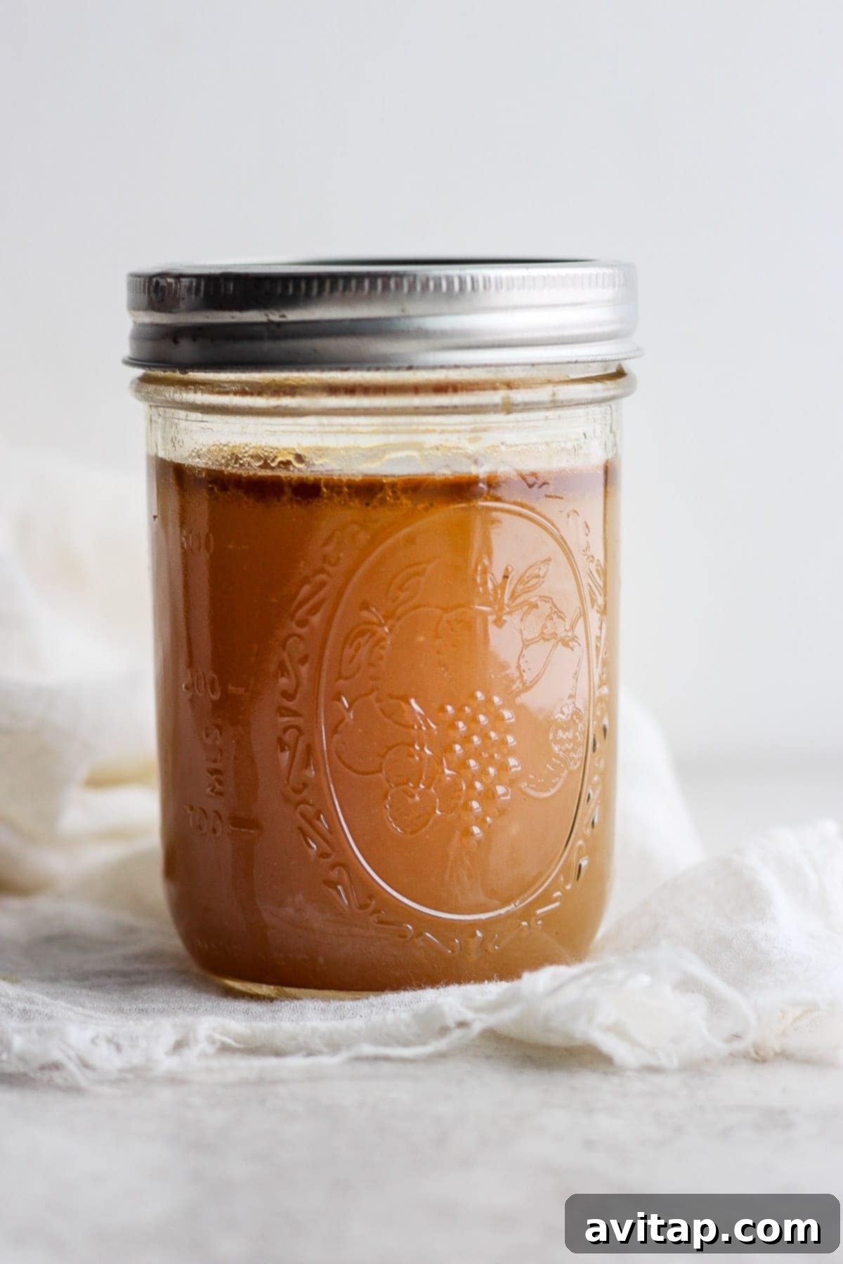 Homemade chicken broth in a mason jar, ready for storage.