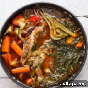 chicken stew with vegetables in a pan on a white background.