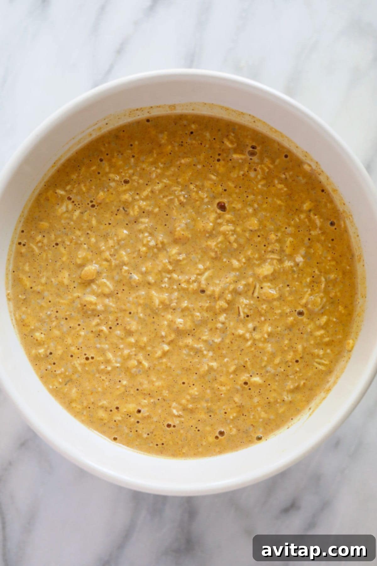 Mixing the Pumpkin Overnight Oats Ingredients All the pumpkin cheesecake overnight oats ingredients thoroughly mixed in a bowl before chilling.