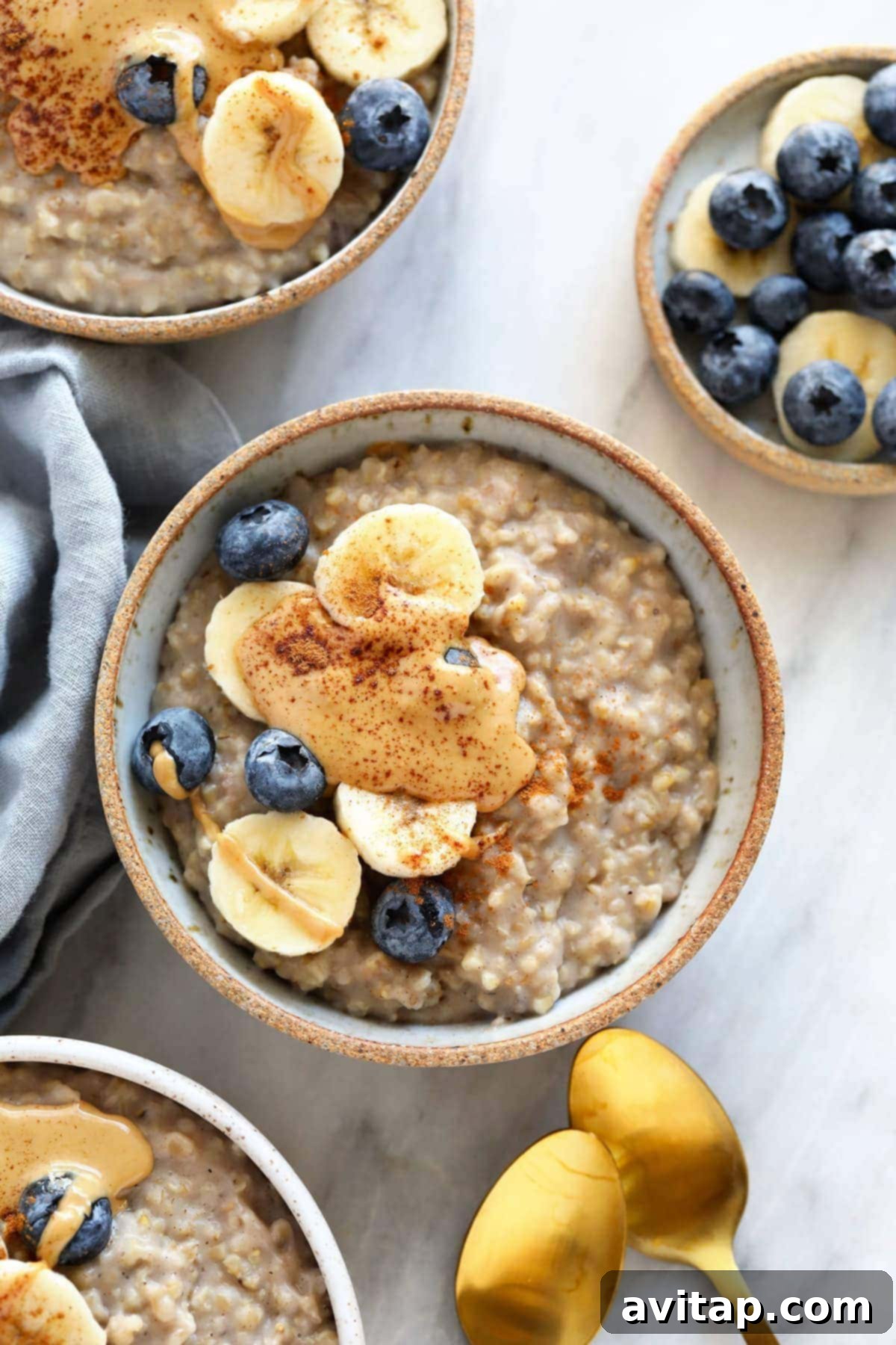 A bowl of steel cut oats topped with banana slices, blueberries, and a dollop of peanut butter, ready for a healthy breakfast.