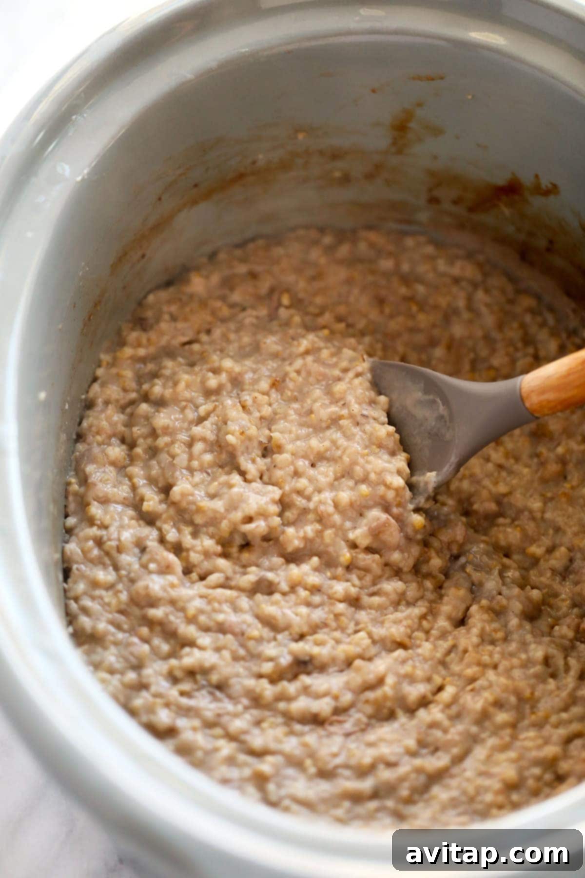 Cooked steel cut oats simmering in a slow cooker, looking creamy and ready to serve.