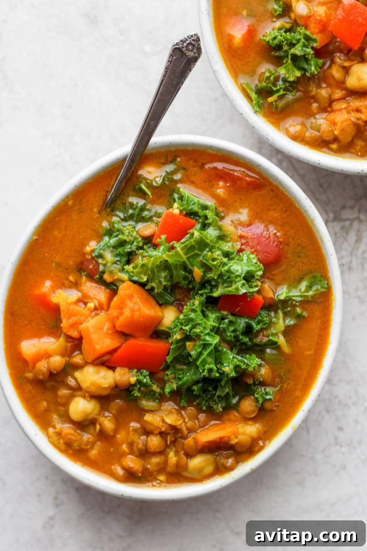 Hearty Instant Pot Lentil Soup 2 Two bowls of Instant Pot Lentil Soup, garnished with fresh herbs and ready to serve.