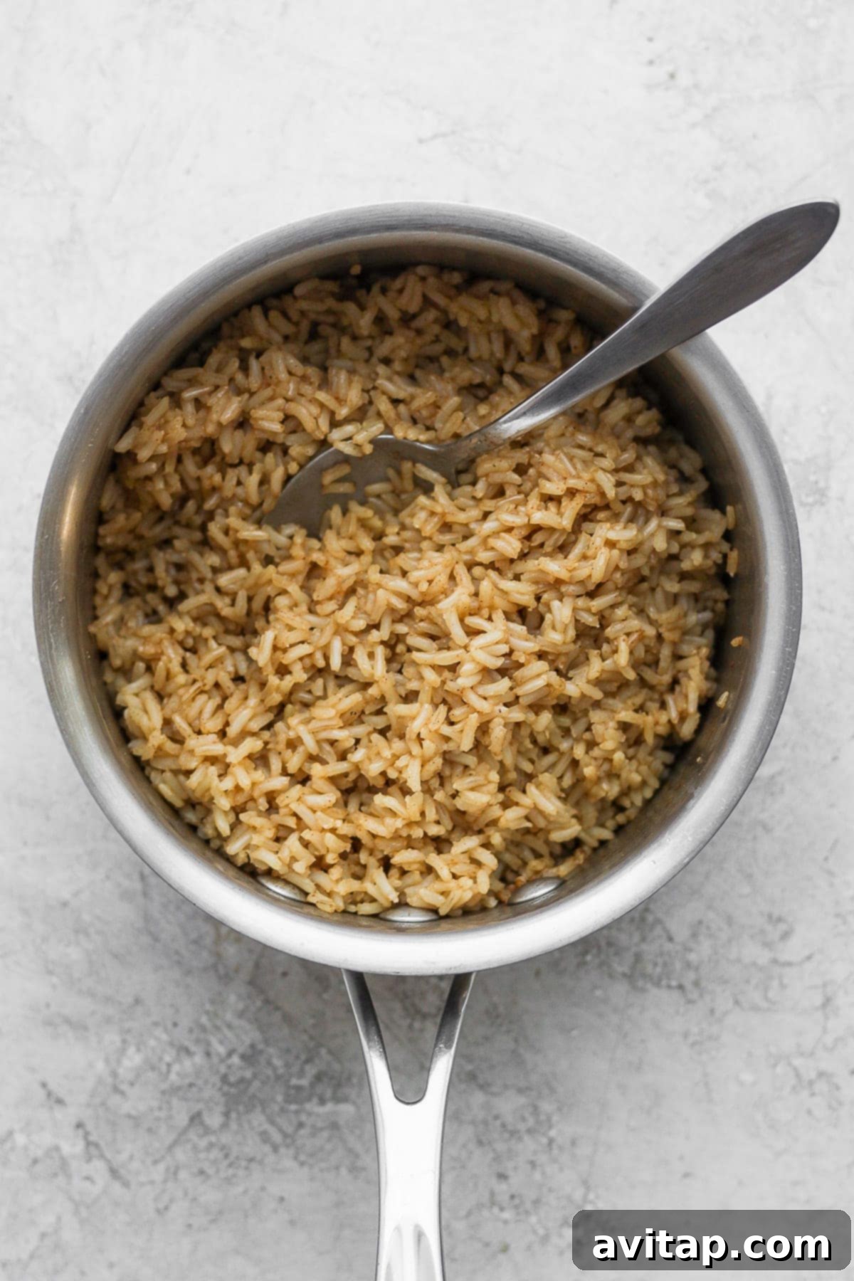 Fluffy brown rice cooked to perfection in a stock pot, ready to be combined with the rich red bean mixture for a complete meal.