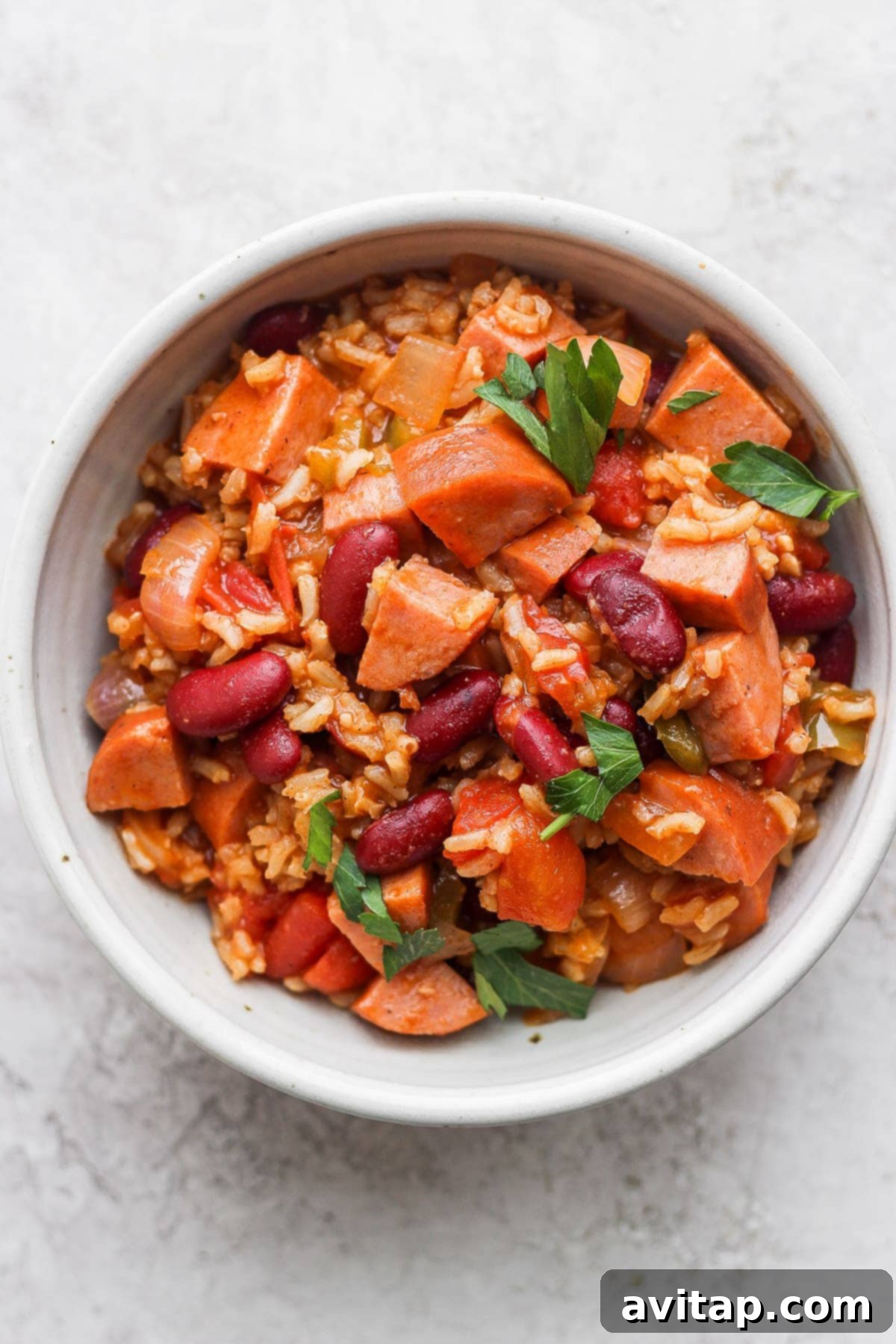 A serving of flavorful red beans and rice in a rustic bowl, garnished with fresh herbs and ready to be enjoyed.