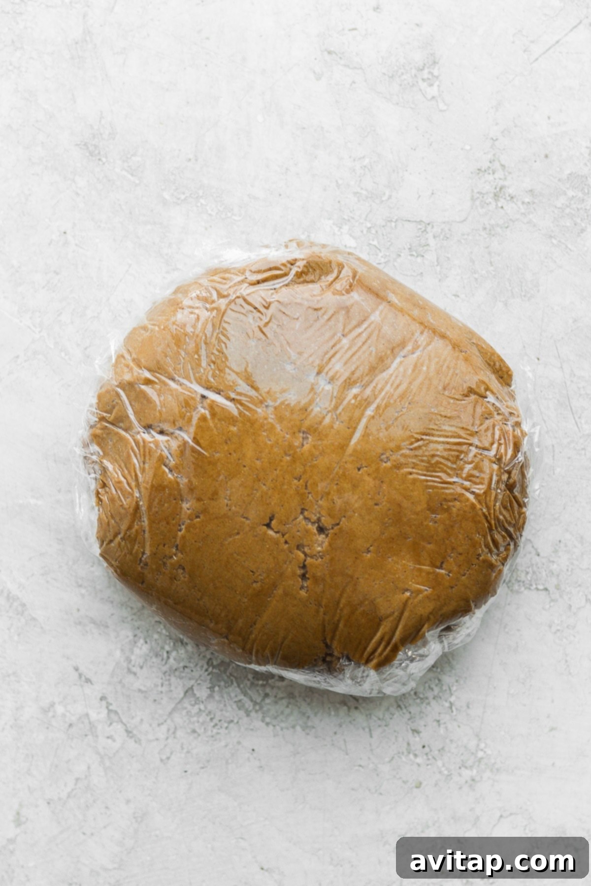 Gingerbread cookie dough, perfectly chilled and wrapped in plastic wrap, ready for rolling.