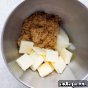 A mixing bowl containing butter, brown sugar, and flour mixture for gingersnap cookies.