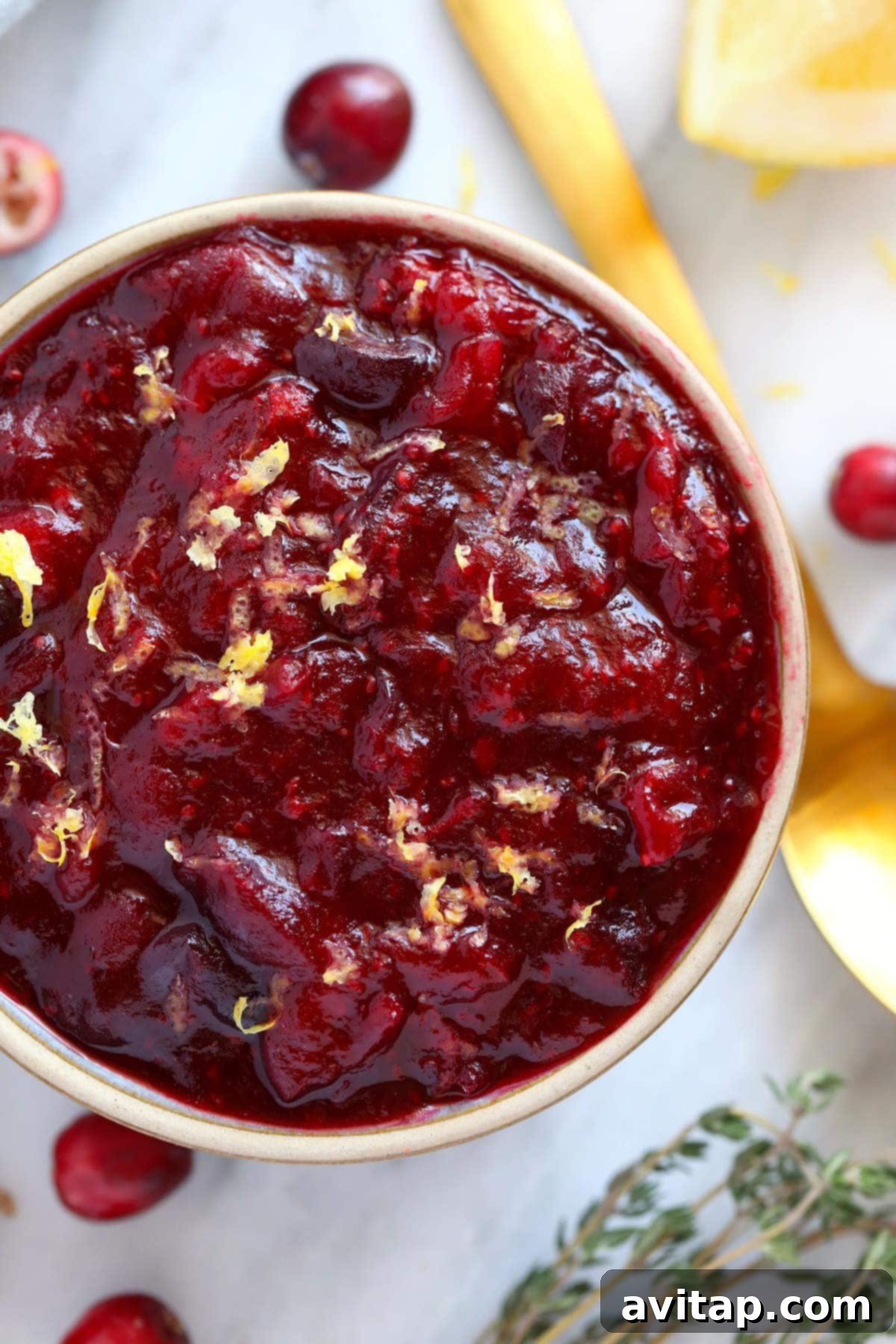 Close-up of vibrant lemon ginger cranberry sauce in a white bowl, ready to be served.