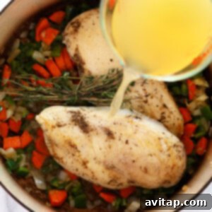 Creamy Chicken Wild Rice Delight 4 a person pouring olive oil into a pan with vegetables to prepare chicken wild rice soup.