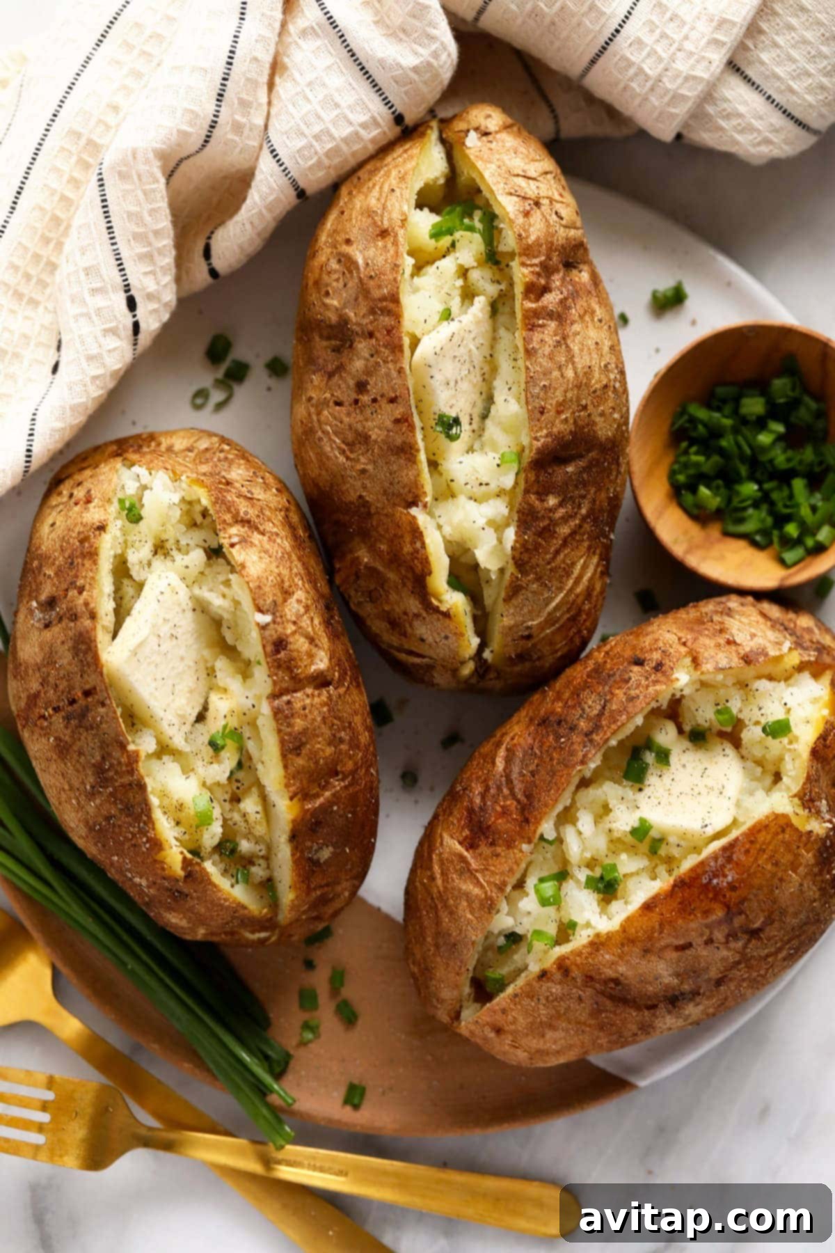 The Ultimate Crispy Fluffy Baked Potato 6 A baked potato loaded with various toppings like sour cream, chives, and bacon bits.