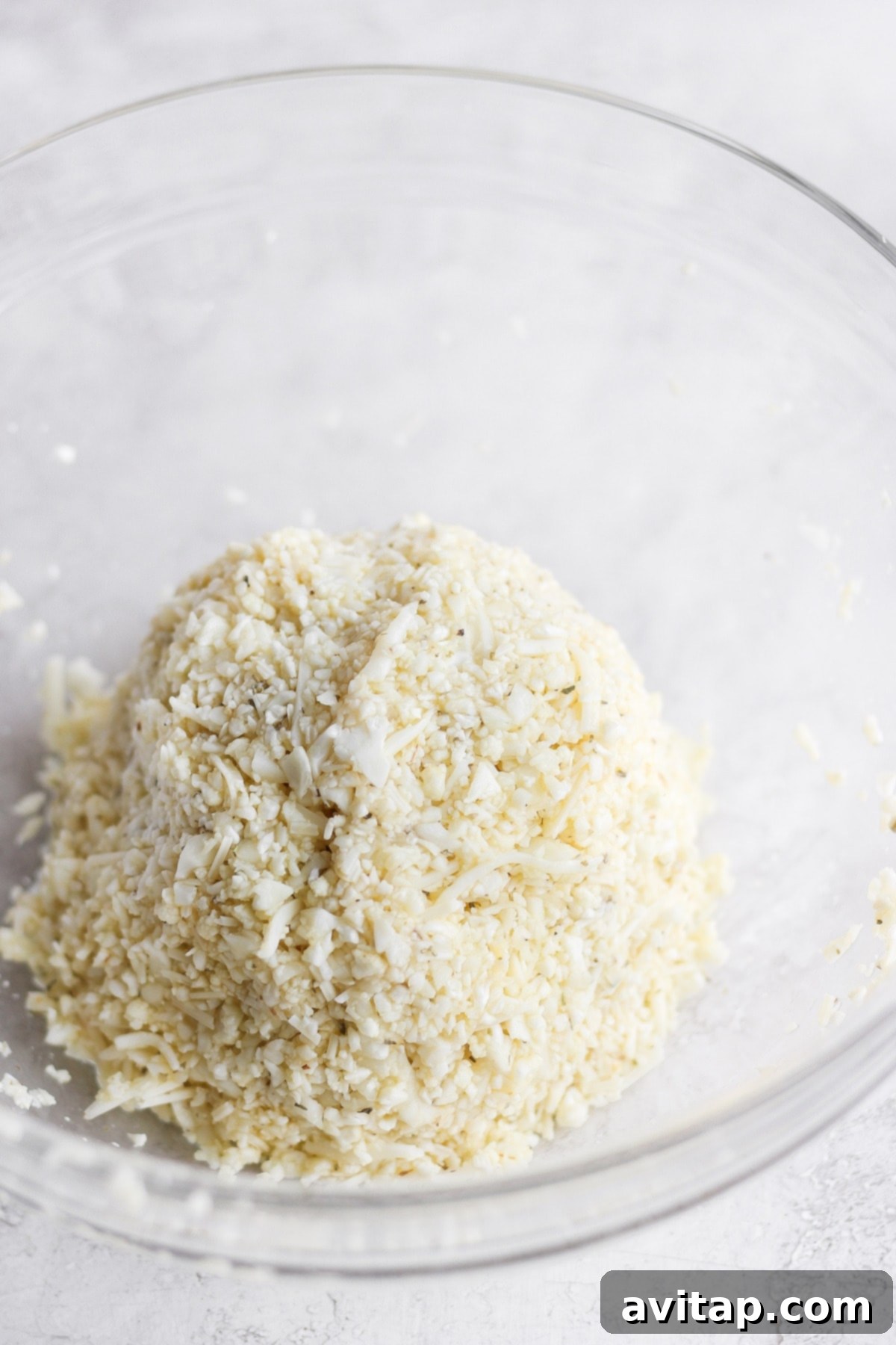 The combined cauliflower pizza crust ingredients shaped into a firm ball, ready to be pressed onto a baking sheet.