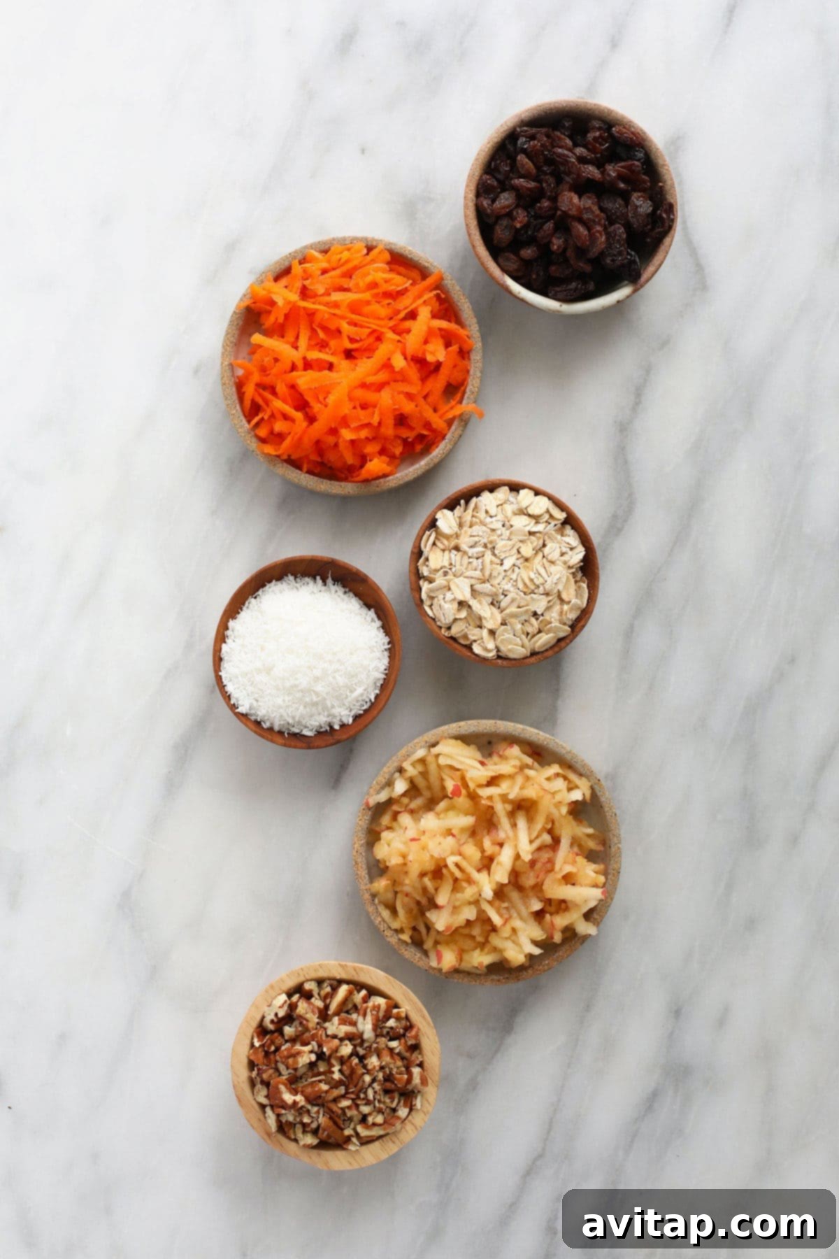 Morning glory muffin ingredients laid out in small bowls.