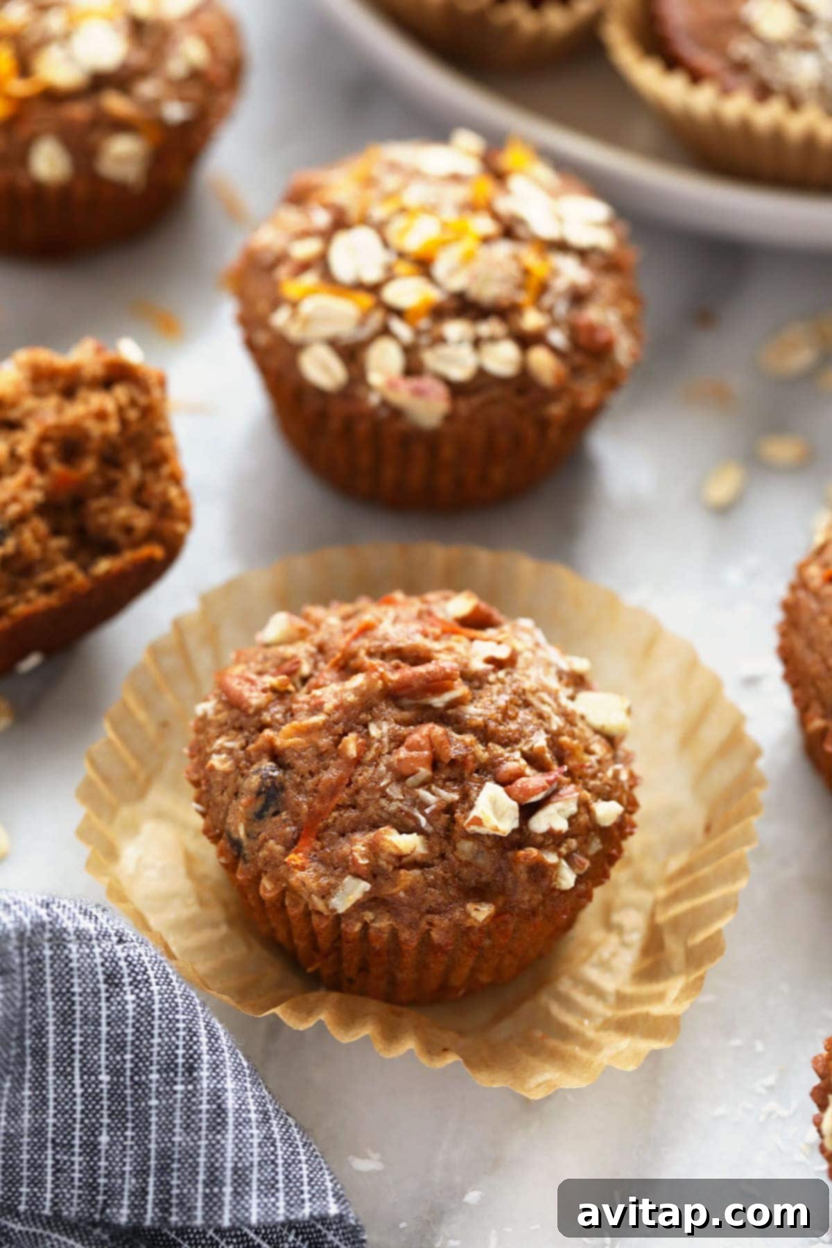 A freshly baked morning glory muffin with oats on top.