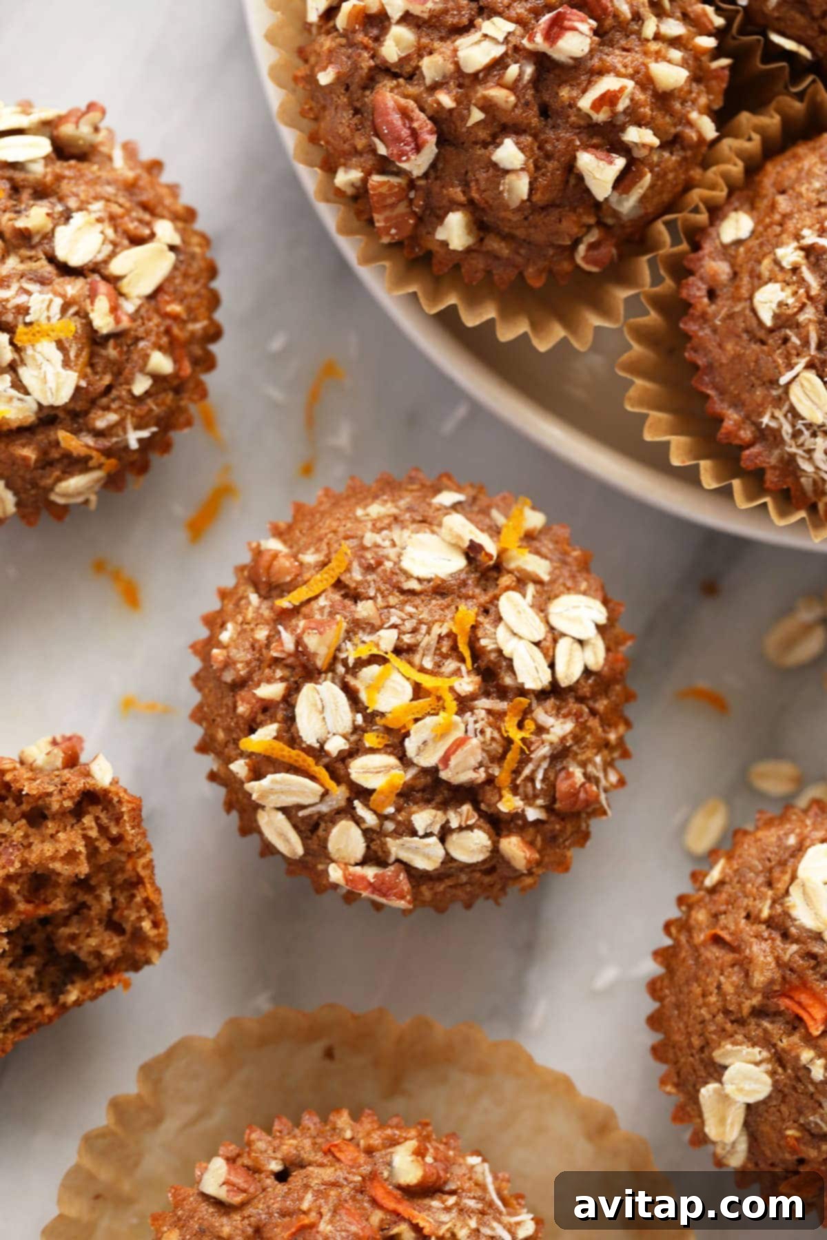 A freshly baked morning glory muffin with fresh orange zest on top.