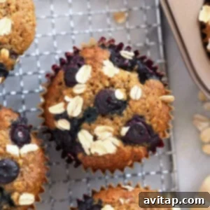 Perfectly baked blueberry oatmeal muffins cooling, showcasing their golden tops and rustic oat texture, ready to be eaten.
