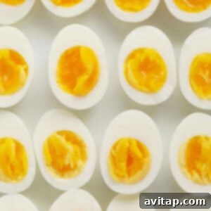 A group of hard boiled eggs on a white surface, freshly cooked.