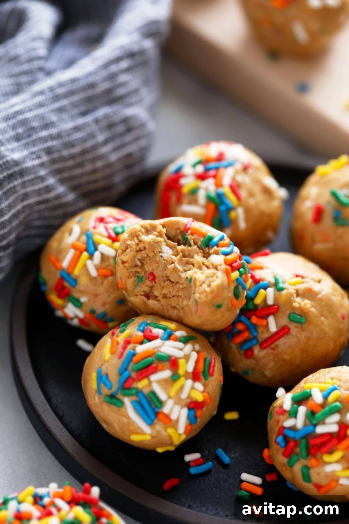 A delicious cake batter protein ball with a bite taken out, revealing the soft, cake-like interior and colorful sprinkles.