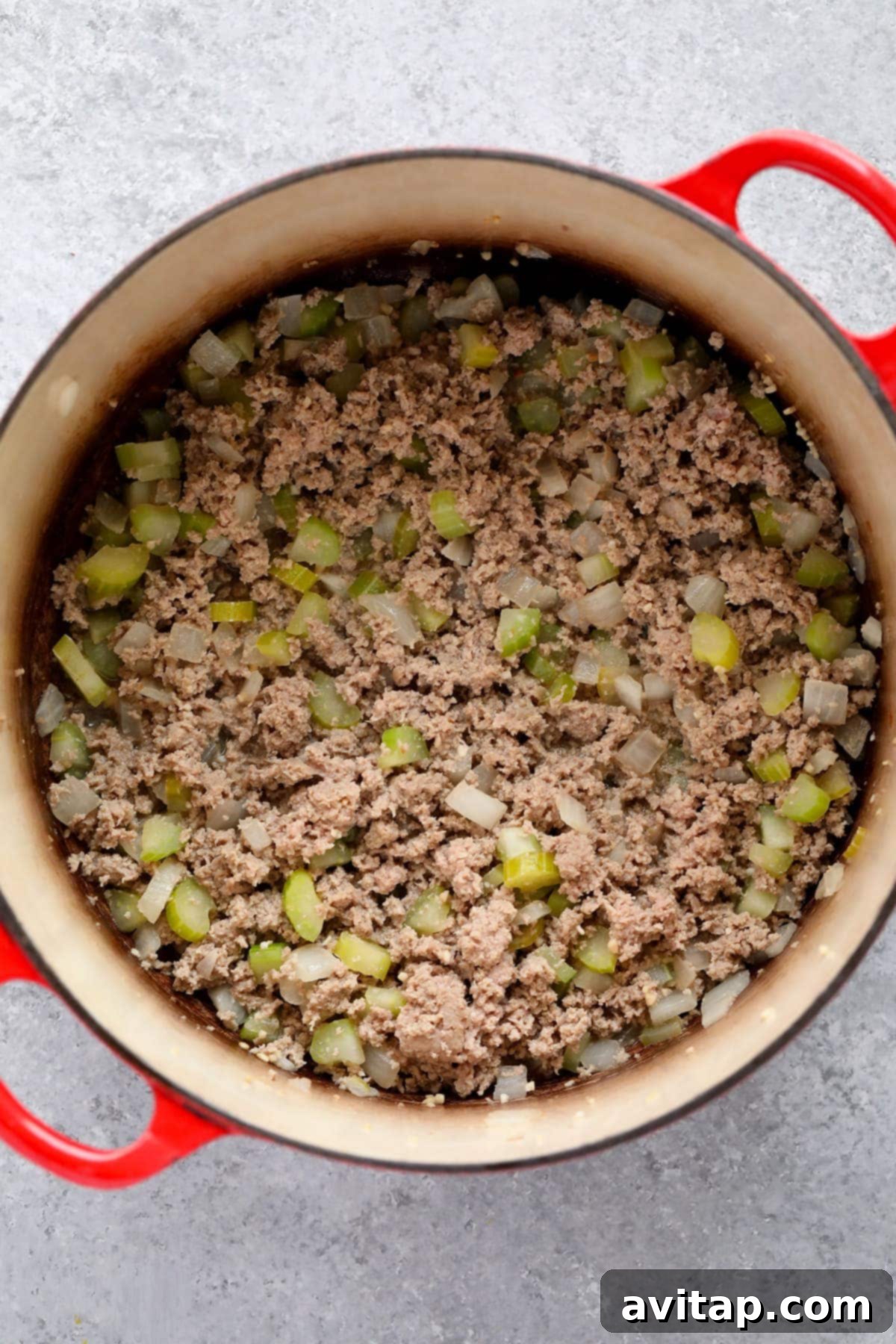 Sautéing Aromatics and Ground Turkey for the Best Chili Ground turkey and aromatic vegetables like onions and celery being sautéed in a large dutch oven, the initial step for a flavorful turkey chili.