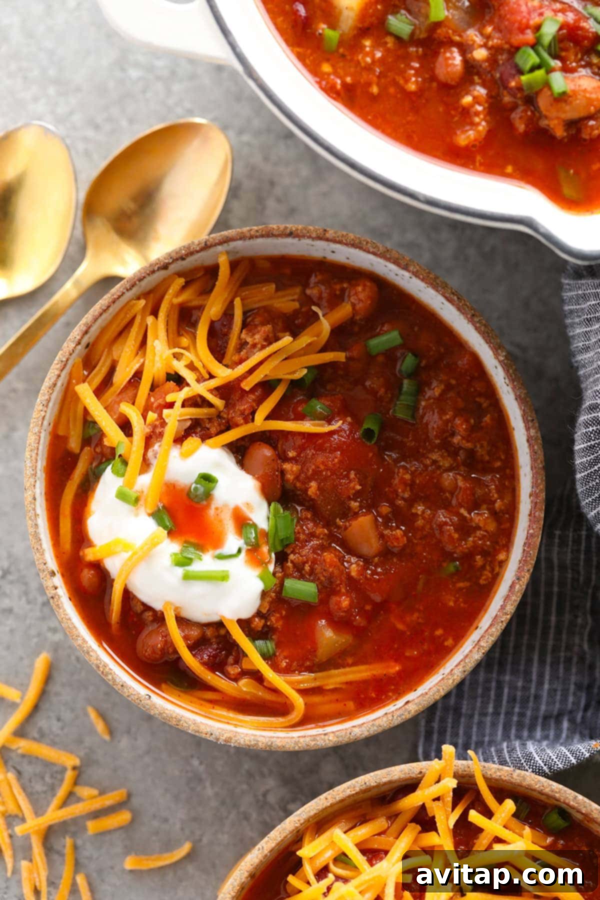 Perfectly Topped Turkey Chili: A Comforting and Flavorful Meal A hearty bowl of turkey chili, beautifully garnished with a swirl of sour cream and a generous sprinkle of shredded cheese, ready to be enjoyed.