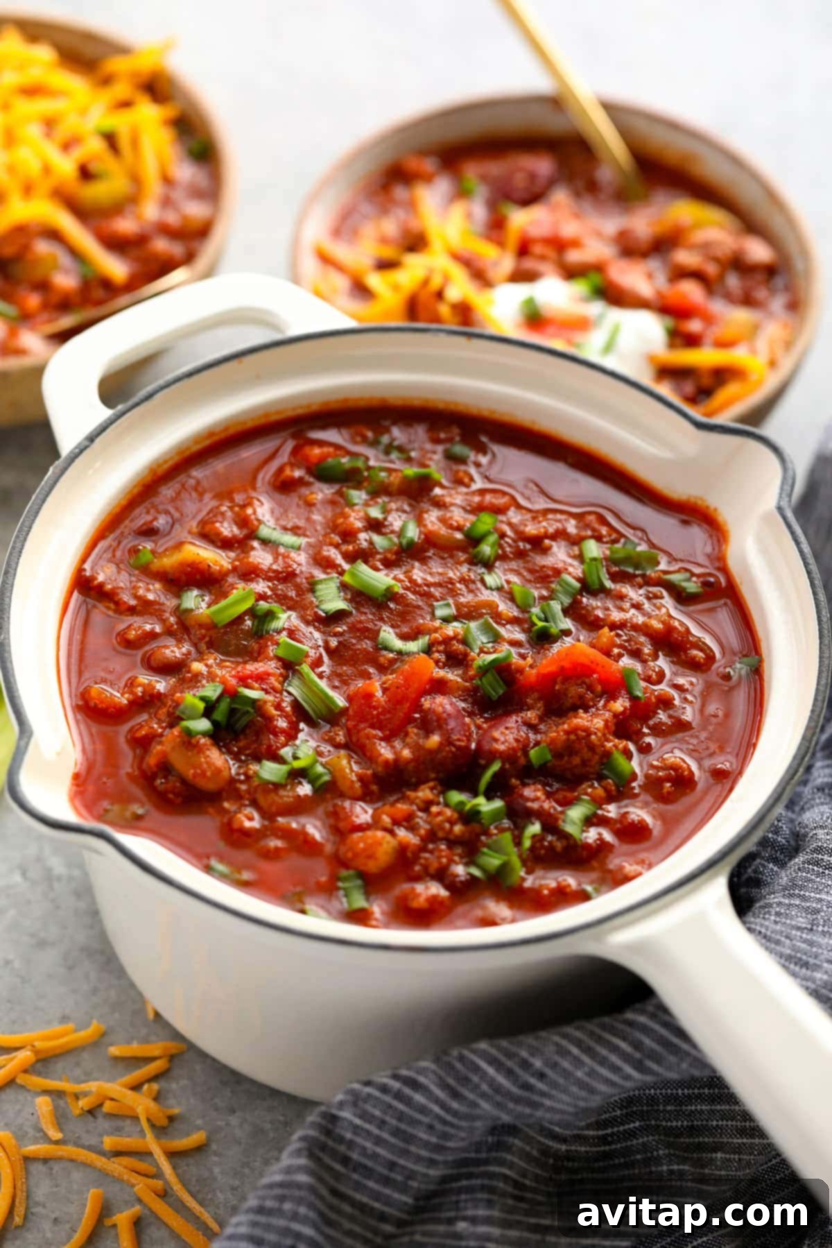 Hearty Turkey Chili Ready for a Delicious Meal A large pot of flavorful turkey chili, garnished with vibrant green onions, showcasing its rich texture and inviting aroma.