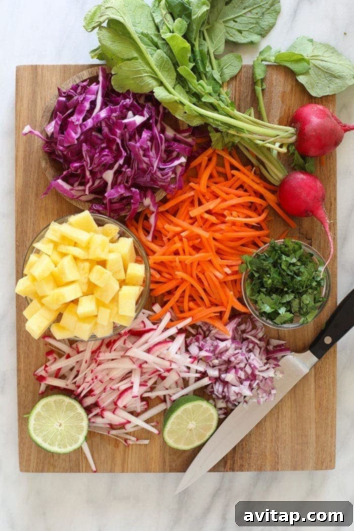 Fresh ingredients for pineapple coleslaw laid out on a wooden cutting board