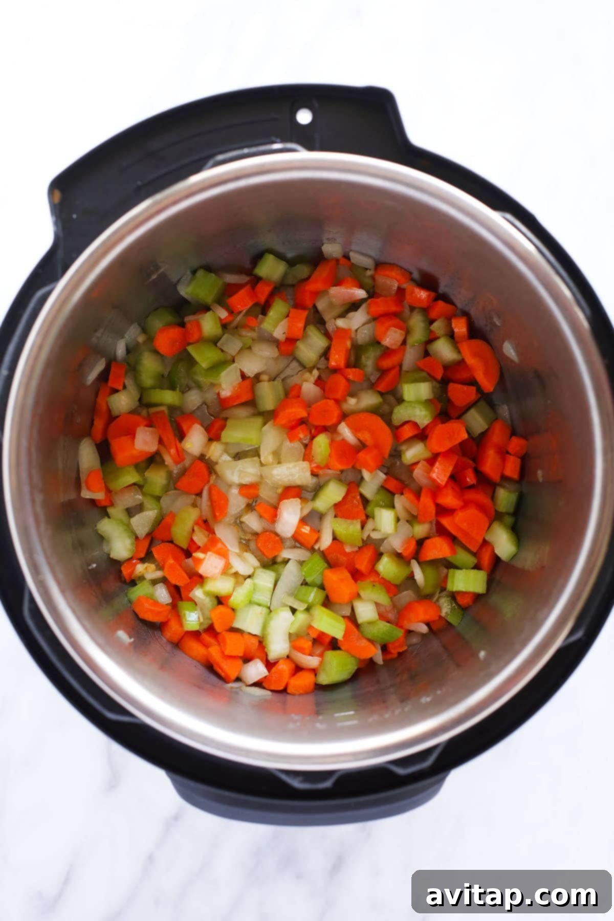Close-up of a bowl of Instant Pot chicken noodle soup, rich in color and texture with visible chicken pieces, noodles, and various vegetables.