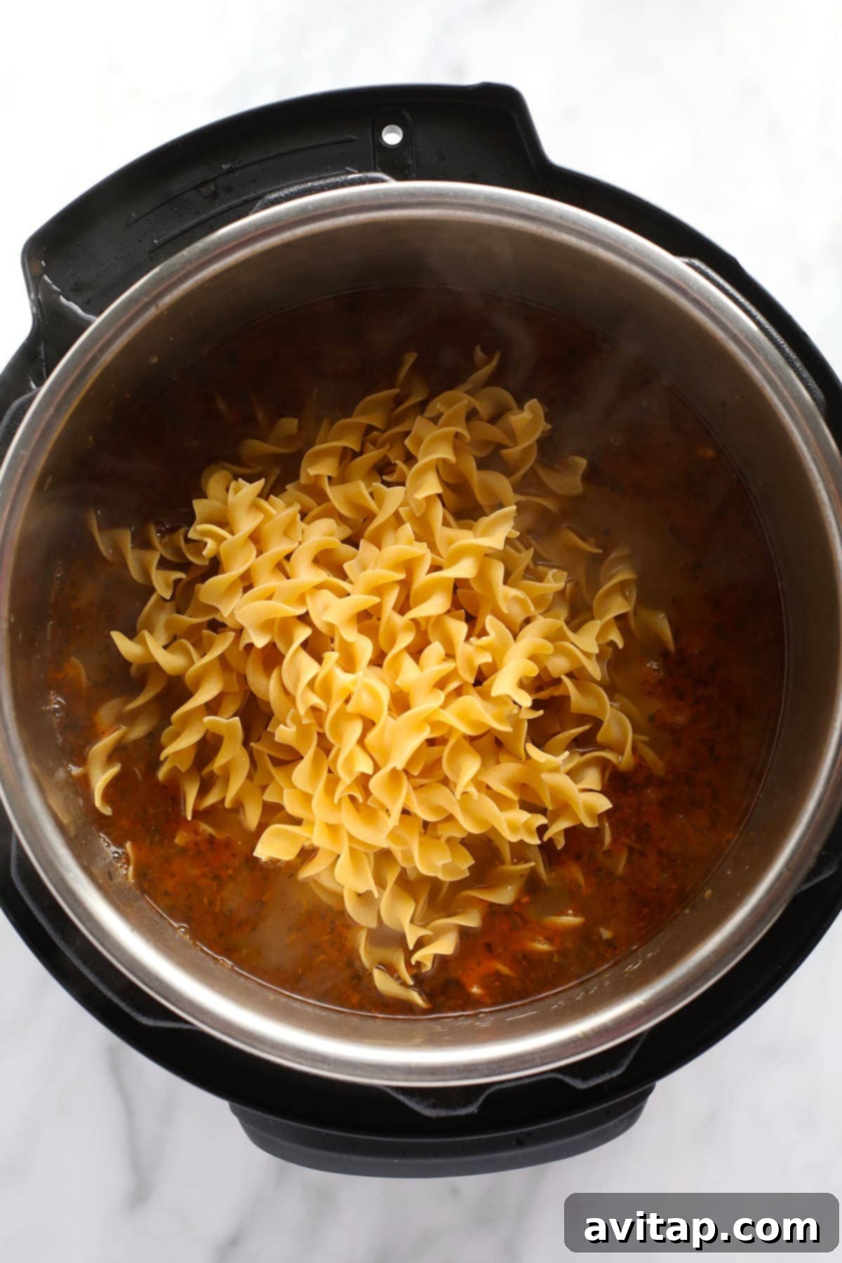 Serving of Instant Pot chicken noodle soup in a modern bowl.