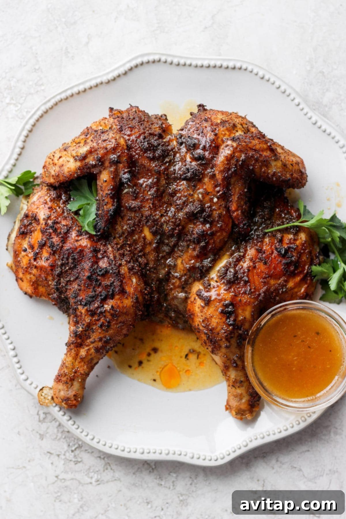 Perfectly roasted spatchcock chicken on a large serving platter, highlighting its golden, crispy skin and tender appearance.