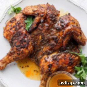 Spatcock chicken on a platter, showcasing the crispy skin and golden-brown finish.