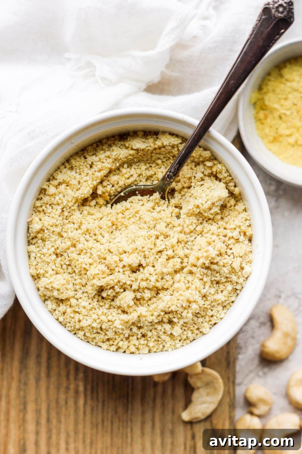 A bowl filled with freshly made vegan parmesan cheese, ready to be sprinkled over a meal.