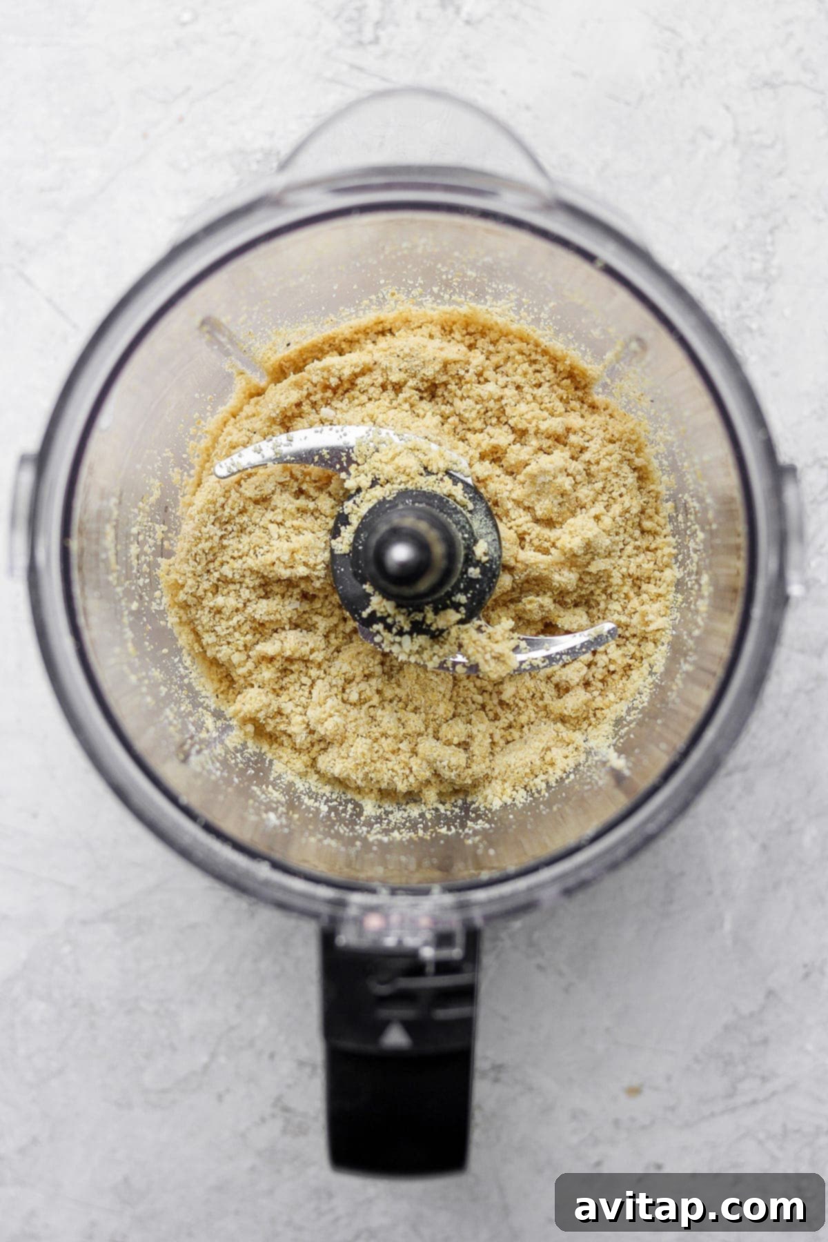 Perfectly blended vegan parmesan cheese resting in a food processor bowl, ready for serving.