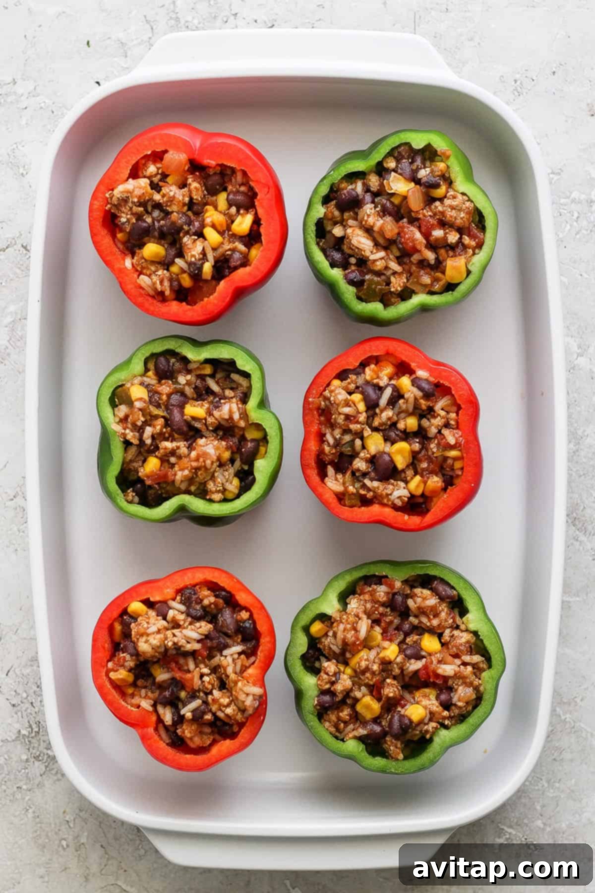 Fiesta-Filled Bell Peppers 5 Stuffed peppers baking in the oven with melted cheese on top.