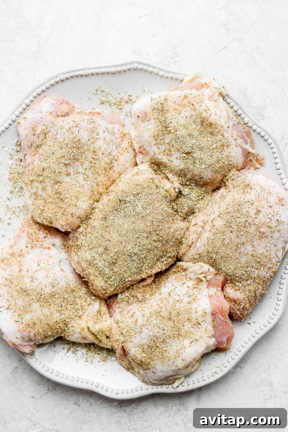 Seasoned bone-in chicken thighs waiting to be seared in a Dutch oven.