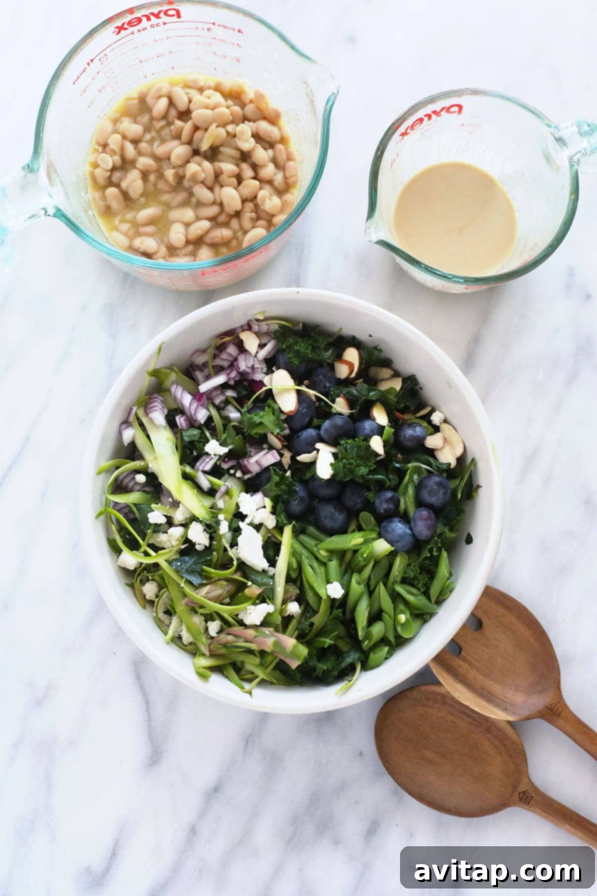 Vibrant Asparagus Salad 3 All the fresh and healthy ingredients for the asparagus salad, including beans, kale, and berries, laid out on a kitchen counter.