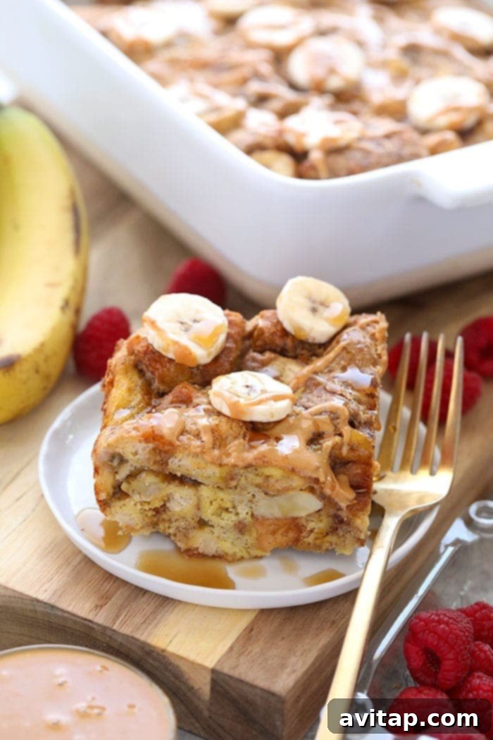 Delicious Peanut Butter Banana French Toast Casserole, golden brown and topped with syrup and fresh bananas.